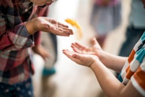 Kinderhände spielen miteinander mit einer Feder